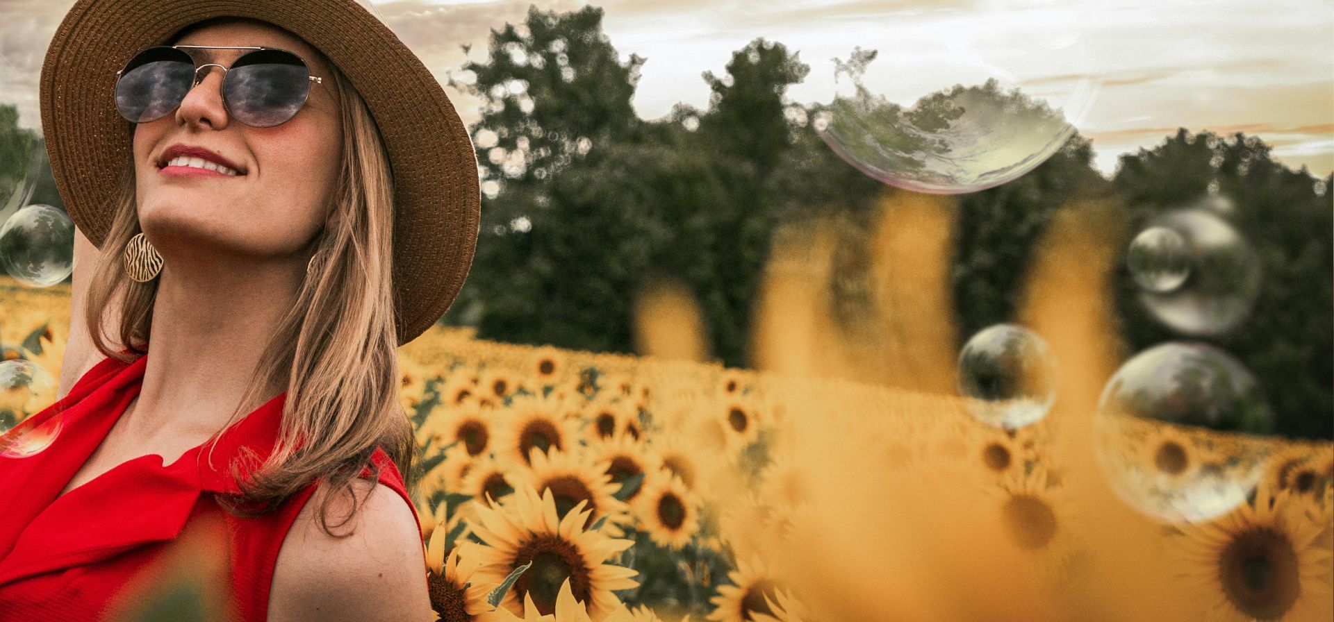 Woman Surrounded by Sunflowers Raising Hand