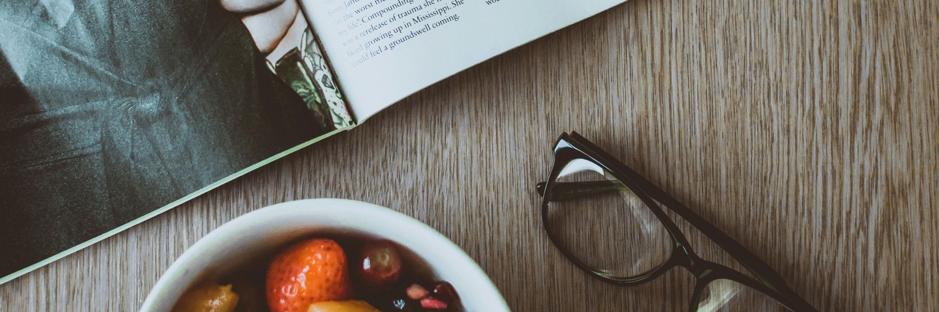 Eyeglasses Beside Bowl of Food and Magazine on Table